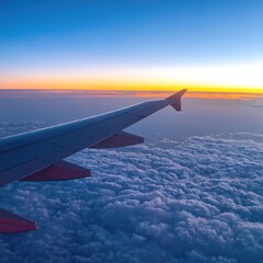 Obraz premium A breathtaking view from an airplane window showcases a sleek wing cutting through fluffy white clouds, bathed in soft sunlight against a blue sky.