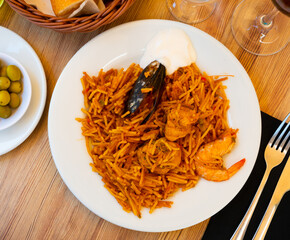 Traditional seafood fideua with mussels, shrimps and chicken