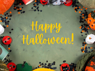 Happy halloween green frame background flatlay with pumpkins and decor