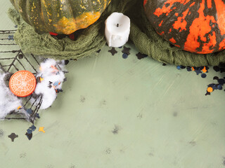 Halloween green frame background flatlay with colorful pumpkins and confetti