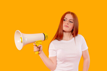 Young woman holding megaphone against bright orange background, confidently encouraging...
