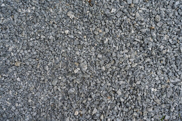 Dark and light gray coarse stones, crushed and broken at a stone pit to similar sizes. The colors and shapes are very irregular.