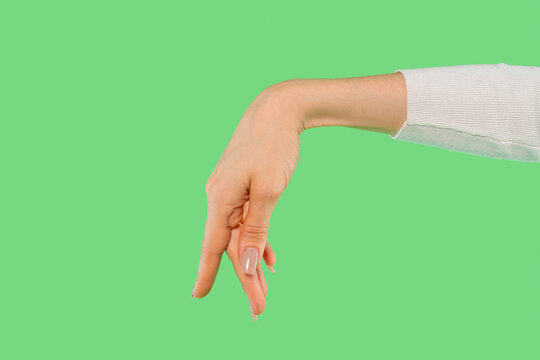 Hand gesture of peace symbol made with fingers against a bright green background, showcasing a creative expression in a playful manner