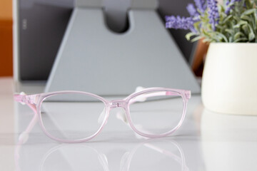 A pair of pink children's glasses on the table