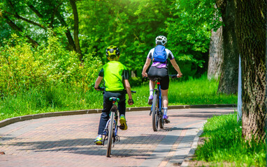 Naklejka premium Cyclists ride on the bike path in the city Park