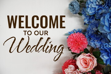 Welcome to our Wedding text with flowers decorations on wooden background