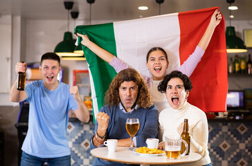 Happy fans celebrating the victory of Italian team in the bar