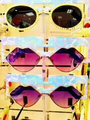 Three stylish, cool sunglasses closely displayed on a store showcase.