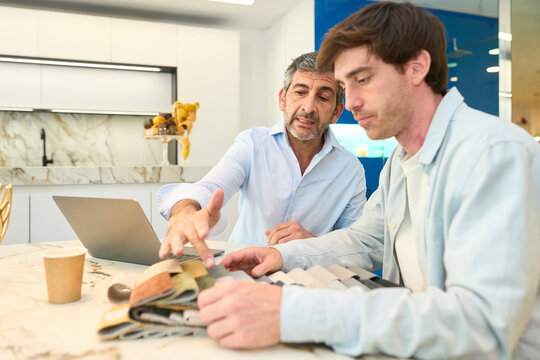 Interior designer showing fabric swatches to client in furniture showroom