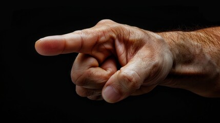 Realistic human hand pointing forward with extended index finger on a black background