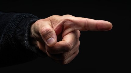 Realistic human hand pointing forward with extended index finger on black background for editing