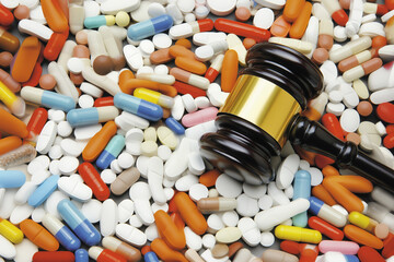 Gavel resting on various prescription drugs, representing legal issues related to pharmaceuticals, addiction, or malpractice