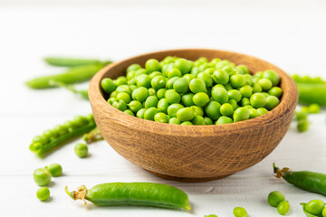 Fresh green pea pods with green peas on a wooden background. Sweet green peas. Green pea beans vegetables. Vegan. healthy vegetable. Copy space