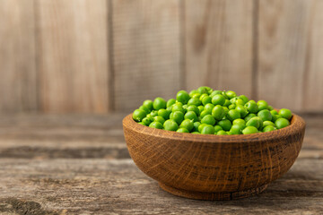 Fresh green pea pods with green peas on a wooden background. Sweet green peas. Green pea beans vegetables. Vegan. healthy vegetable. Copy space