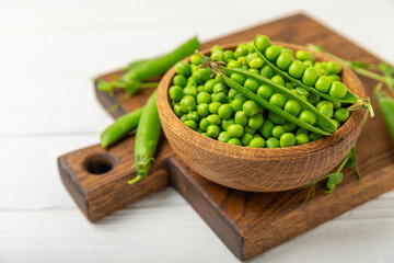 Fresh green pea pods with green peas on a wooden background. Sweet green peas. Green pea beans vegetables. Vegan. healthy vegetable. Copy space