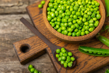 Fresh green pea pods with green peas on a wooden background. Sweet green peas. Green pea beans vegetables. Vegan. healthy vegetable. Copy space