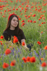 Young Woman in Poppy Field with Red Hat