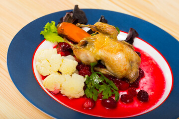 Fried quail with cranberry sauce, caramelized carrots, herbs and vegetables