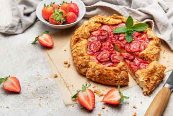 Delicious homemade strawberry galette with almond petals baking on parchment paper