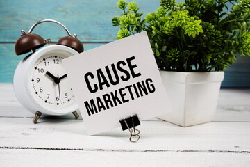 Cause Marketing text written on paper card with alarm clock on wooden background