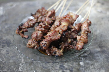 grilled goat satay in a glass plate