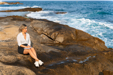 Businesswoman working remotely by the sea taking notes on a notebook