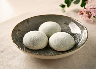 drei weiße Mochi in einem grauen keramik teller