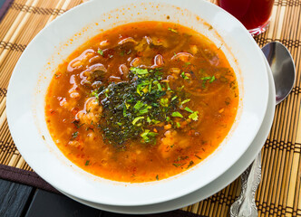 Hot soup Kharcho - traditional dish of Georgian cuisine. Rich mutton broth with rice and tomatoes