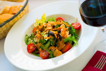 Appetizing sea salad with Seafood Cocktail, lettuce, cherry tomatoes and pink sauce