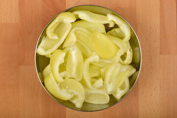 A top-down view of a bowl filled with sliced pale yellow bell peppers, ready for preparation