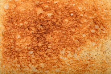 A close-up shot of a toasted white bread surface with a golden-brown texture