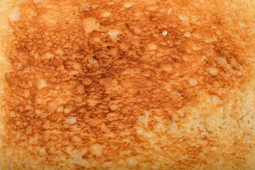 Fototapeten Brot A close-up shot of a toasted white bread surface with a golden-brown texture  © nahhan
