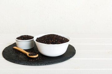 quinoa seeds in bowl and spoon on colored background. Healthy kinwa in small bowl. Healthy superfood
