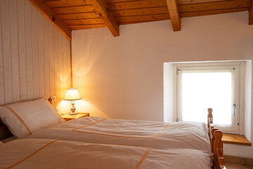 Interior of a double bedroom with two beds in a mountain hut.