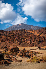 Hiking through the rugged volcanic rock Landscape on Tenerife with Mount Teide in the distance