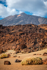 Hiking through the rugged volcanic rock Landscape on Tenerife with Mount Teide in the distance
