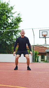 Young athletic man warming up before training outdoors. Man in sports shorts and raglan doing sports. Healthy lifestyle
