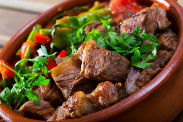 Prepared tasty dish ghiveci of bulgarian cuisine of beef with paprika at clay pot