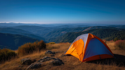 Orange tent on mountain with scenic view at sunrise.