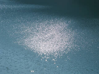 さざ波と太陽の光で水面がキラキラ輝く写真素材