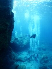 underwater scenery of big rocks topography scuba divers exploring