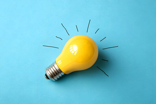 Bright electric lightbulb on a vibrant yellow or blue background, representing ideas, energy, and technological inspiration ai generated