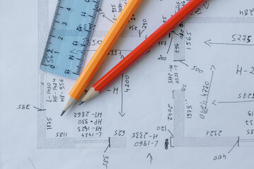 Detailed construction plan layout with precise measurements and drawing tools placed on top of technical drawings