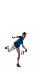 Smiling young male tennis athlete in blue sporty outfit finishing shot movement, joyful posture against white studio background. Concept of sport, victory celebration, tennis joy