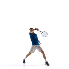 Tennis player stretching low to return fast ball, full body lunge with arm extended against white studio background. Concept of sport, speed response, critical match point, victorious point