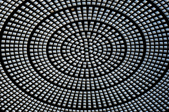 Abstract circular glass ceiling featuring intricate radial patterns and geometric symmetry.