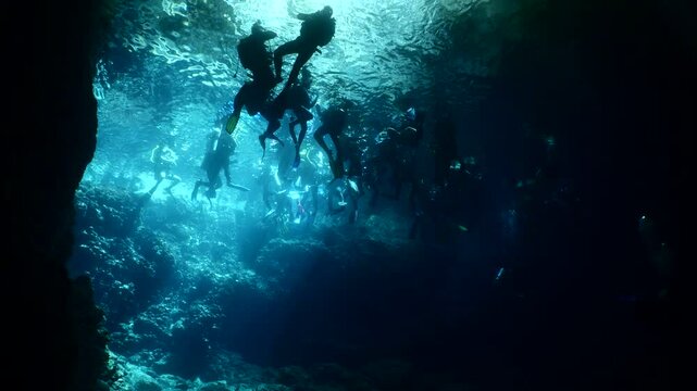 people are making a circle to make a pose for fotograph in an underwater cave