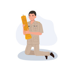 Thai government officer kneels while holding a large candle during Buddhist Lent, a cultural ceremony.