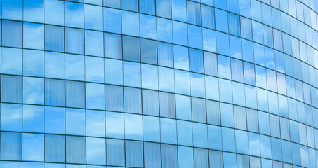 Obraz premium Modern glass facade of an office building with blue sky reflections. Perfect for business, corporate identity, technology, and real estate themes in design or marketing visuals.