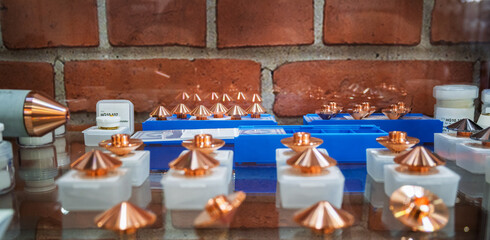 Various Copper Laser Cutting Nozzles on Display Ready for Installation in a Shop Environment